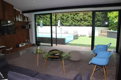 a living room with a couch and chairs and a pool at Villa Le Ruisseau in Cannes