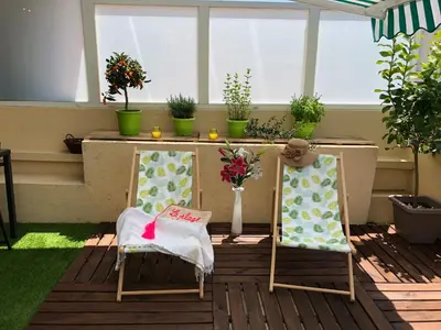 two chairs on a porch with a table and flowers at Appartement Cosy Calme Central-Terrasse Proche Palais in Cannes