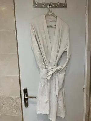 a robe is hanging on a wall in a bathroom at Appartement Cosy Calme Central-Terrasse Proche Palais in Cannes