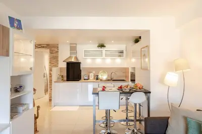 a kitchen and living room with a table and chairs at Appartement Cosy Calme Central-Terrasse Proche Palais in Cannes
