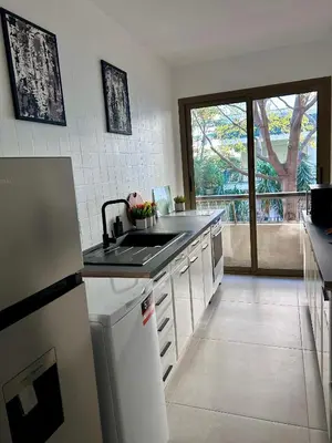 a kitchen with a sink and a refrigerator at Residences Fleuries - behind Cannes Croisette Bvd in Cannes