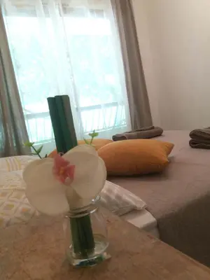 a vase with flowers on a table next to a bed at Residences Fleuries - behind Cannes Croisette Bvd in Cannes