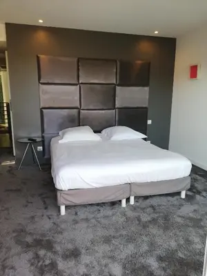 a bedroom with a large bed with a large headboard at Villa Roi Albert 2 in Cannes