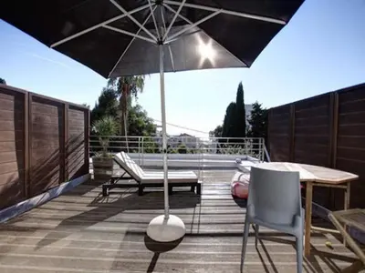 a patio with an umbrella and a table and chairs at Villa Roi Albert 2 in Cannes