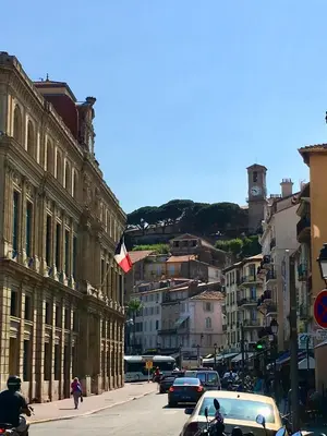 a city street with cars and a flag on a building at Appartement moderne à Cannes, 45 m², proche des plages in Cannes