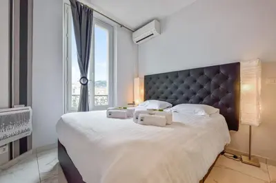 a bedroom with a large bed with a large window at IMOOGROOM - Modern - City Center - AC - 9 min from the Palais in Cannes