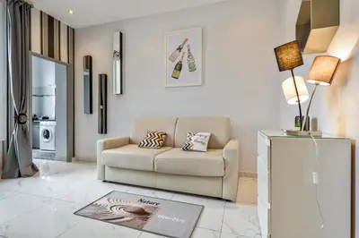 a living room with a couch and a lamp at IMOOGROOM - Modern - City Center - AC - 9 min from the Palais in Cannes