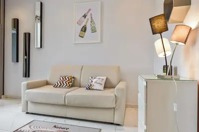 a living room with a couch and a lamp at IMOOGROOM - Modern - City Center - AC - 9 min from the Palais in Cannes