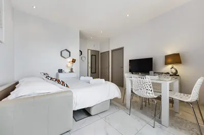 a bedroom with a bed and a desk with a computer at IMOOGROOM - Modern - City Center - AC - 9 min from the Palais in Cannes