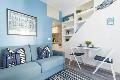 a living room with a blue couch and a table at Azur Studios Cannes in Cannes