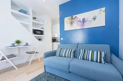 a blue couch in a living room with a blue wall at Azur Studios Cannes in Cannes