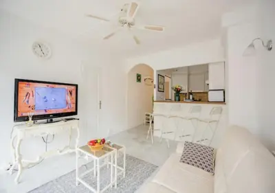 a living room with a white couch and a tv at Cannes Apartment 3 mins from the beach in Cannes