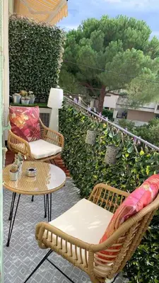 a patio with two chairs and a table on a balcony at Aby in Cannes
