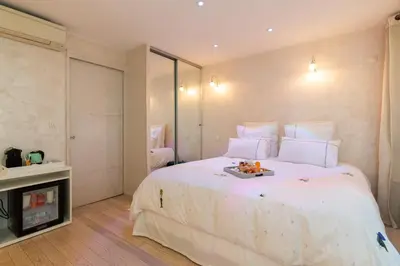 a bedroom with a white bed with a tray of food on it at Aby in Cannes