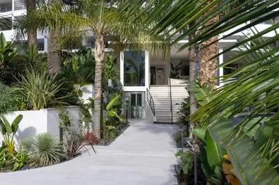 an indoor garden with palm trees and a walkway at Staybridge Suites - Cannes Centre by IHG in Cannes