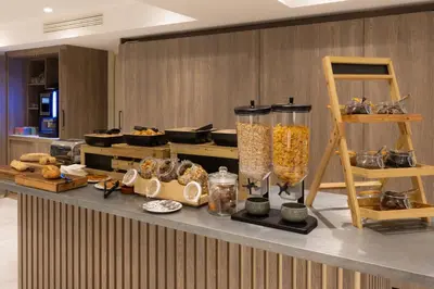 a buffet with bread and other food items on a counter at Staybridge Suites - Cannes Centre by IHG in Cannes