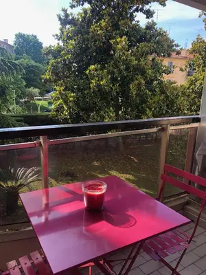 a pink table on a balcony with a cup on it at Cannes center in Cannes