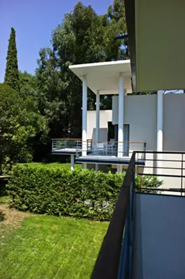 a white house with a porch and a fence at Arthur Properties - Montfleury in Cannes