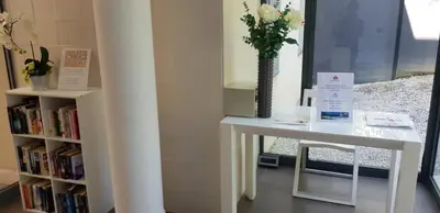 a white table with a vase of flowers and a book shelf at Arthur Properties - Montfleury in Cannes