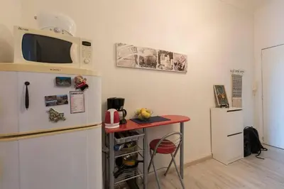 a kitchen with a red table next to a refrigerator at RIVIERA STUDIO CANNES CENTER in Cannes