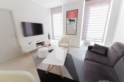a living room with a couch and a tv at Alceste Apartment - Cannes Banane in Cannes
