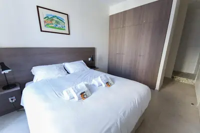 a bedroom with a white bed with two pillows at Alceste Apartment - Cannes Banane in Cannes