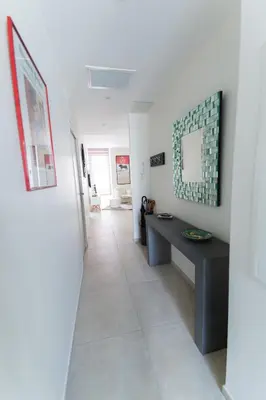 a hallway with a table and a mirror on the wall at Alceste Apartment - Cannes Banane in Cannes
