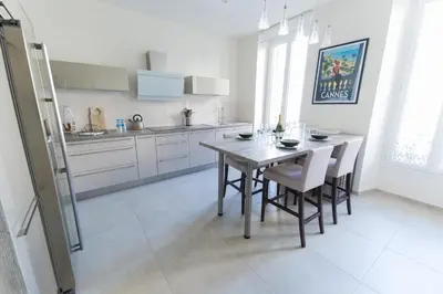 a kitchen with a table and chairs in a room at Alceste Apartment - Cannes Banane in Cannes