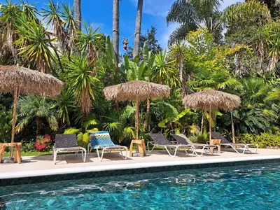 a group of chairs and umbrellas next to a swimming pool at Residence Veles Plage in Cannes
