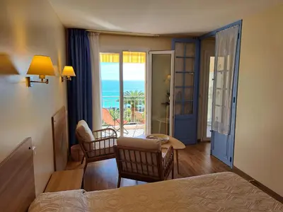 a bedroom with a bed and a table with chairs at Residence Veles Plage in Cannes