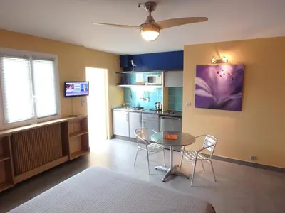 a bedroom with a bed and a table and purple walls at Residence Veles Plage in Cannes