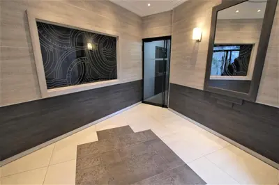 a hallway with a glass door in a building at VENDÔME APARTMENT in Cannes
