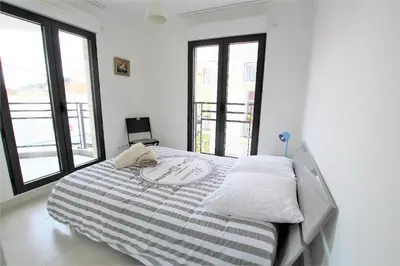 a bedroom with a large bed with windows at VENDÔME APARTMENT in Cannes