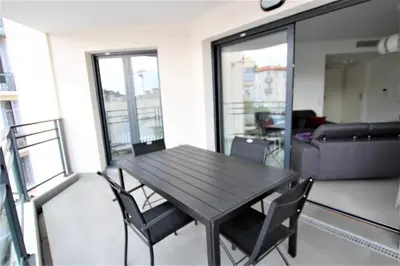 a wooden table and chairs in a room with a couch at VENDÔME APARTMENT in Cannes