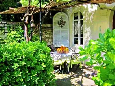 a porch of a house with a bench in the yard at Bed & Breakfast Chambres d'hôtes COTTAGE BELLEVUE in Cannes