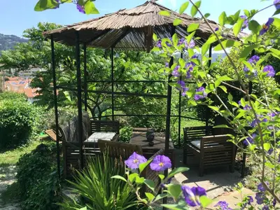 a gazebo with chairs and tables in a garden at Bed & Breakfast Chambres d'hôtes COTTAGE BELLEVUE in Cannes