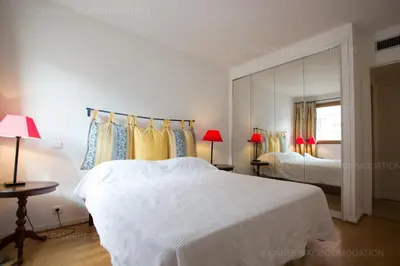 a white bedroom with two beds and a mirror at Alessandra in Cannes