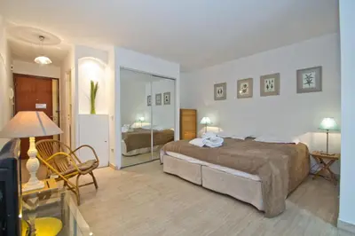a bedroom with a large bed and a room with a bed sqor at Antares POP in Cannes