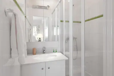 a white bathroom with a sink and a shower at Blanc cel in Cannes