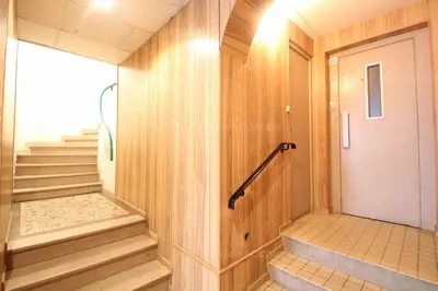 a hallway with wooden walls and stairs with a white door at Blanc cel in Cannes
