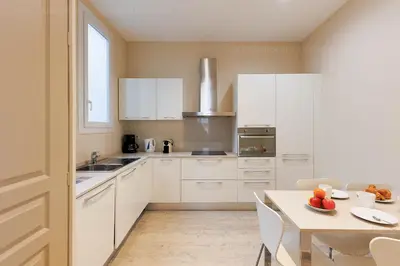 a kitchen with white cabinets and a table with fruits on it at Carrousel 4 in Cannes