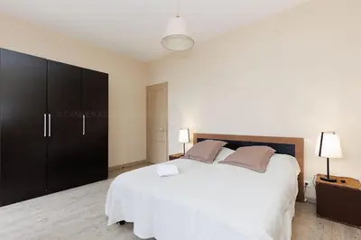 a bedroom with a large bed and a black cabinet at Carrousel 4 in Cannes