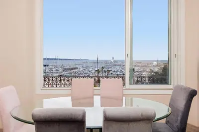 a dining room with a table and chairs and a large window at Carrousel 4 in Cannes