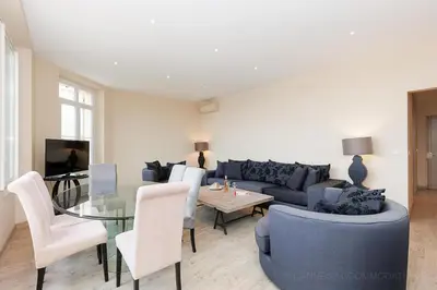 a living room with a blue couch and a glass table at Carrousel 4 in Cannes