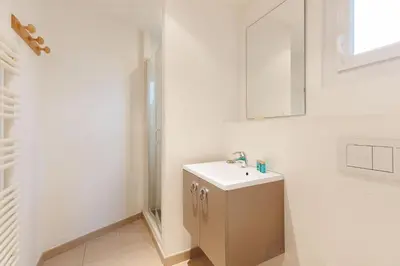 a white bathroom with a sink and a mirror at Carrousel 5 in Cannes