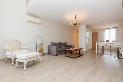 a white kitchen with a white table and chairs at Carrousel 5 in Cannes