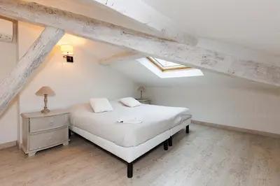 a bedroom with a white bed in a attic at Carrousel 5 in Cannes