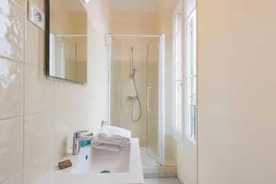 a white bathroom with a shower and a sink at Carrousel stud in Cannes