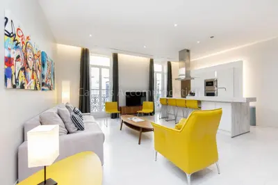 a living room and kitchen with yellow chairs and a couch at Clic 20 in Cannes