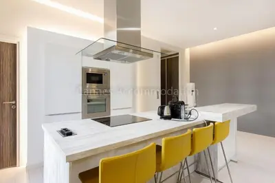 a kitchen with a counter with yellow chairs at Clic 20 in Cannes